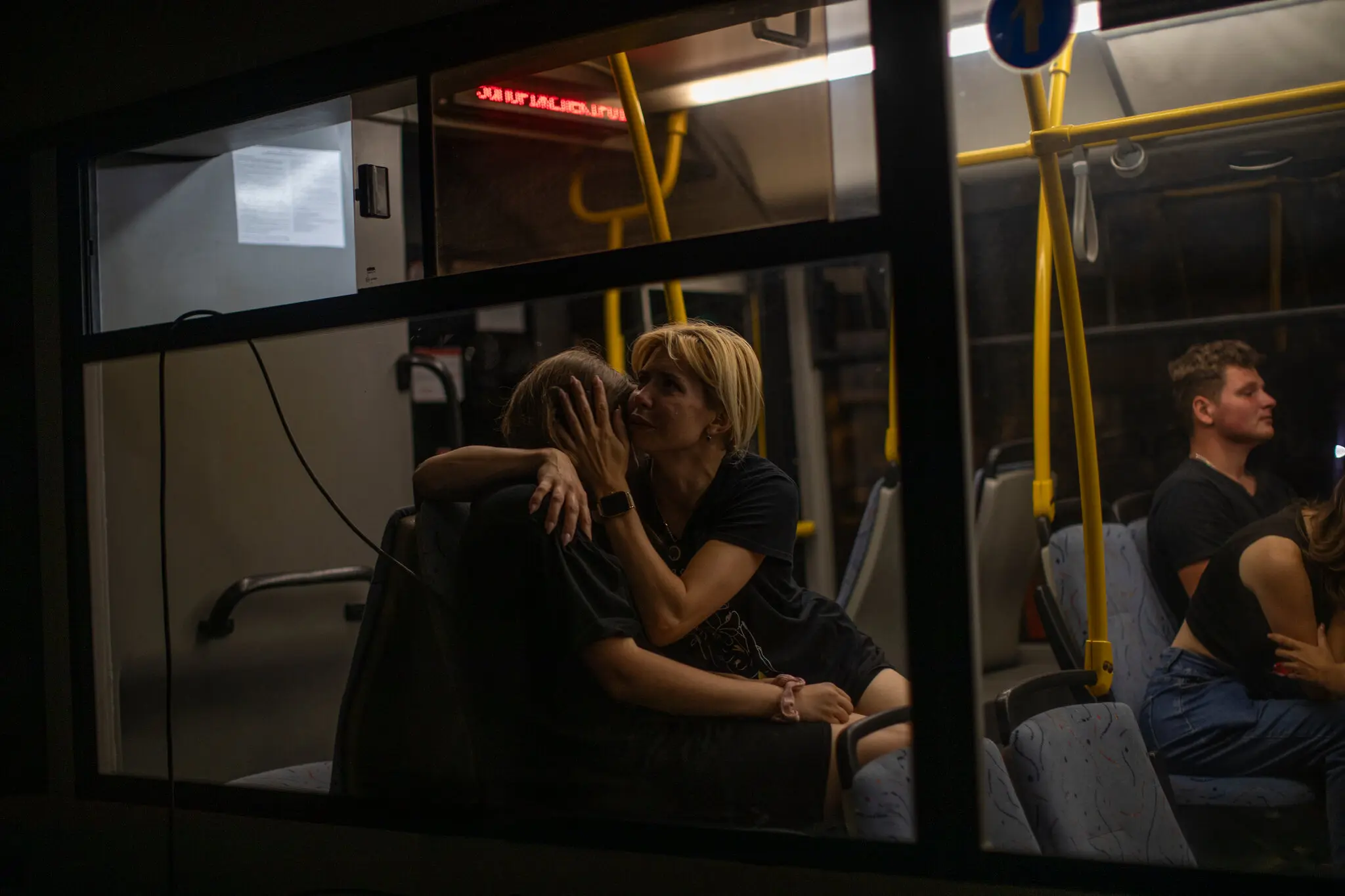 Жінка втішає дочку після ракетного обстрілу житлового району Запоріжжя 9 серпня